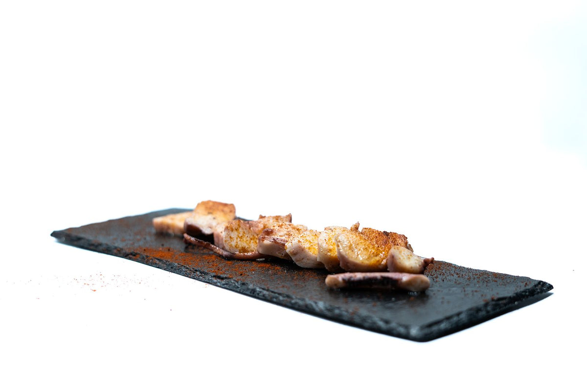 Pulpo aliñado con pimentón sobre pizarra